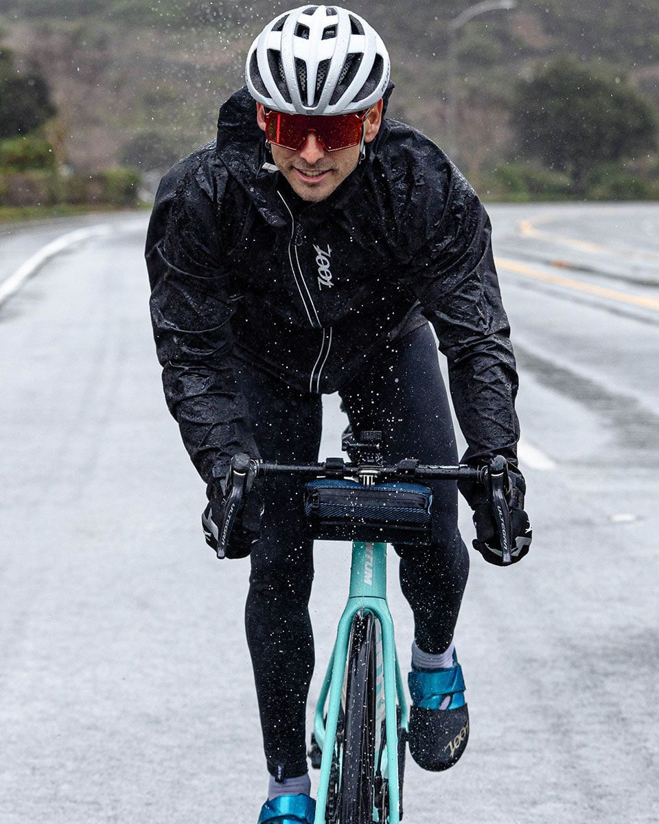 Male cyclist biking in the rain wearing Men's Elite FlashJacket - Black
