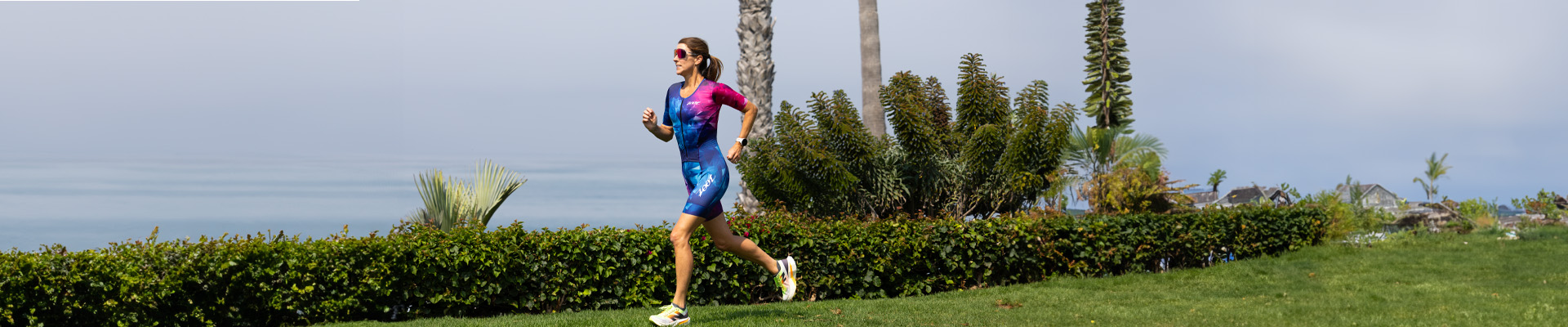 Woman running in racesuit on the beach