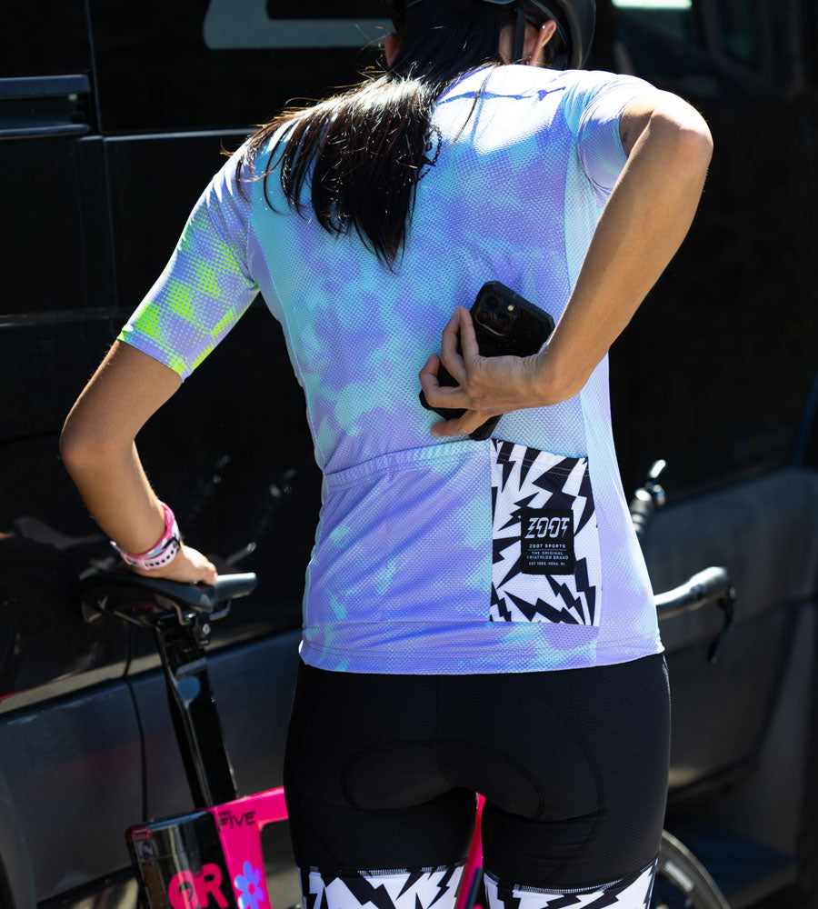 Female wearing Electric cycle jersey putting phone in pocket