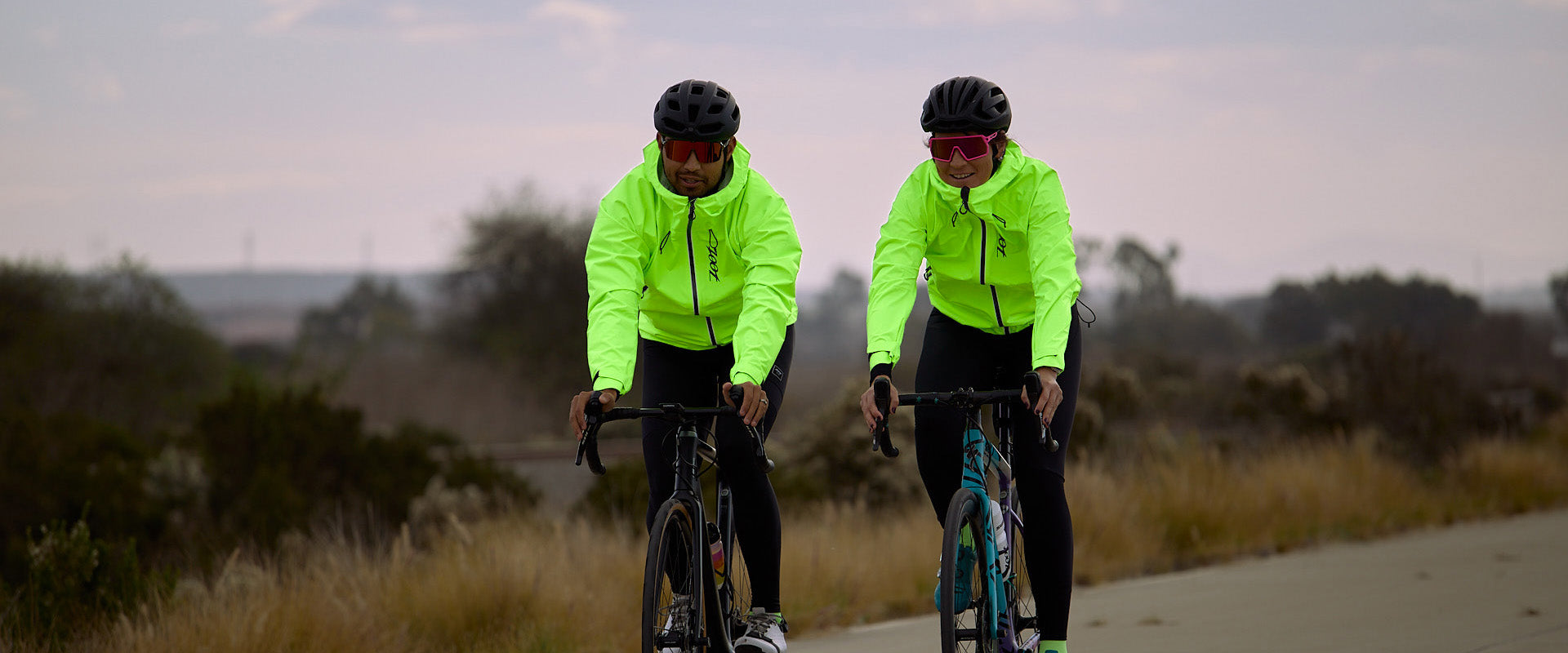 Male and female biking in hi-viz jackets